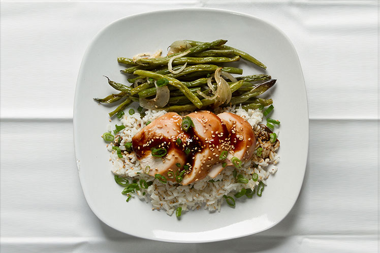 Teriyaki glazed grilled chicken over white rice with roasted green beans and shallots.